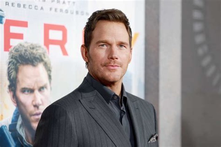 Chris Pratt smiling in a suit at the premiere of 'Guardians of the Galaxy Vol. 3'.