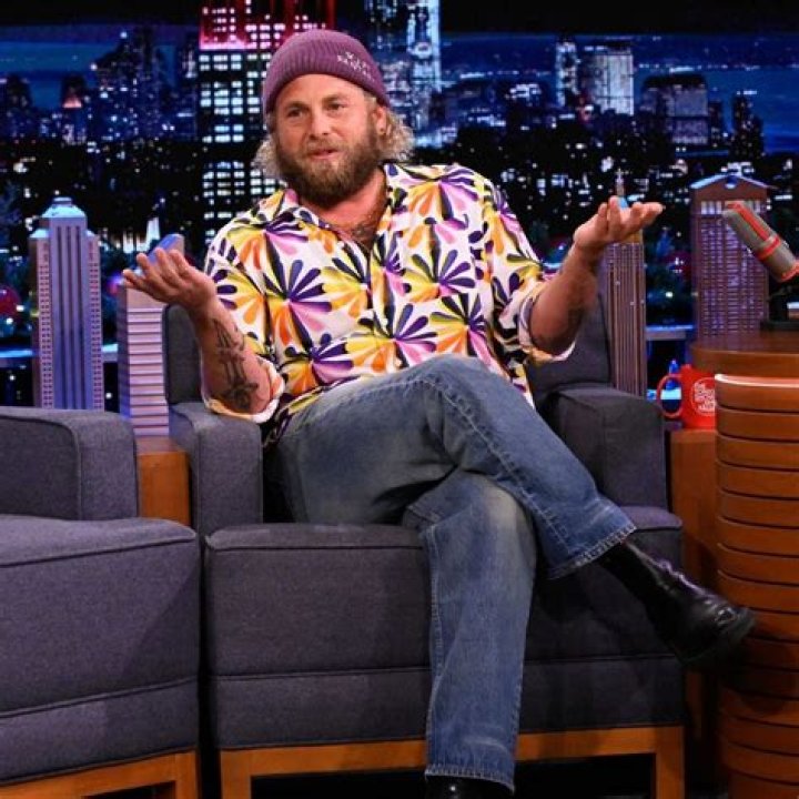 Jonah Hill posing while wearing a blue suit.